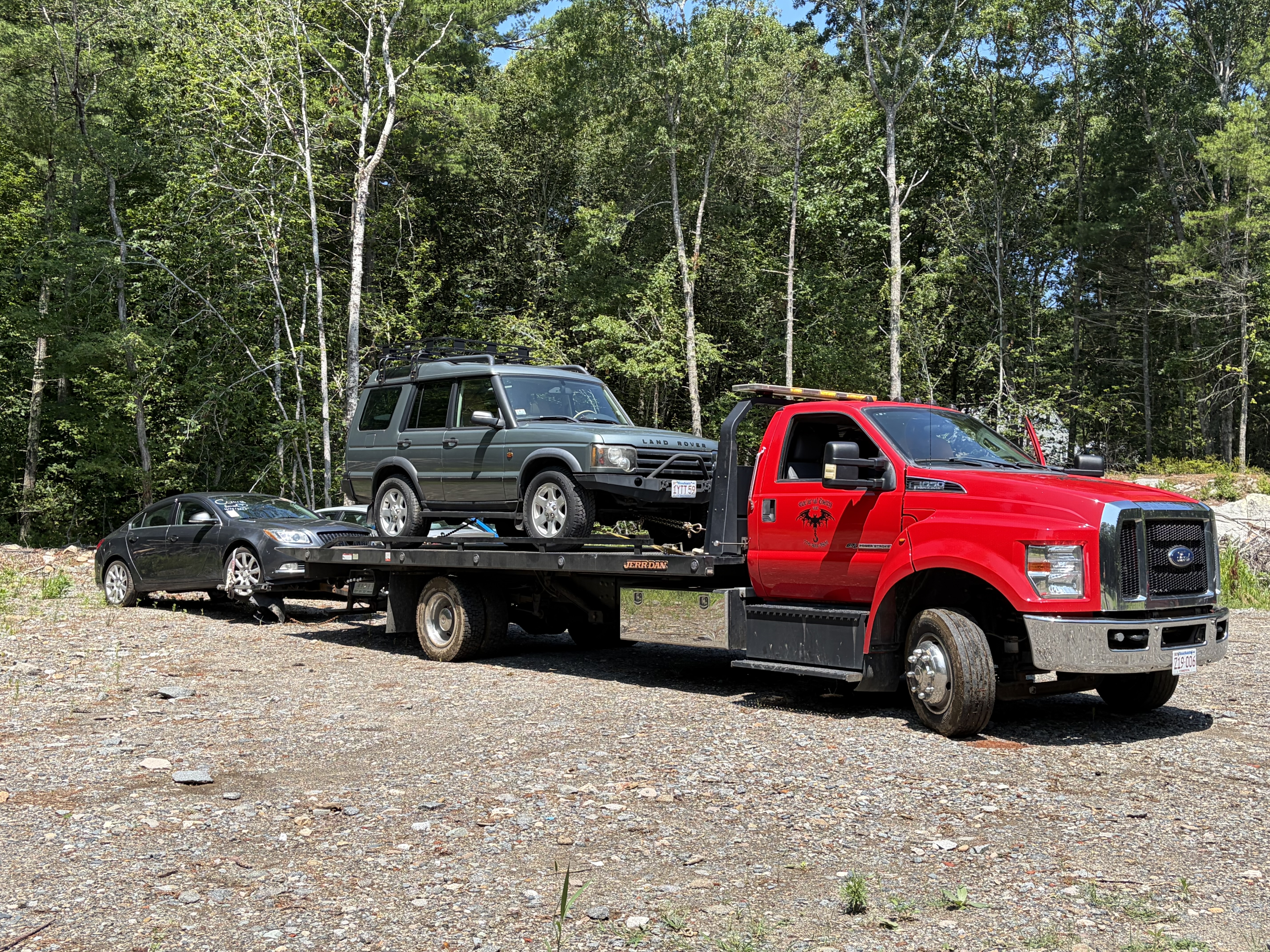 Nocturnal Towing flatbed hauling a Land Rover and sedan in southeastern Massachusetts